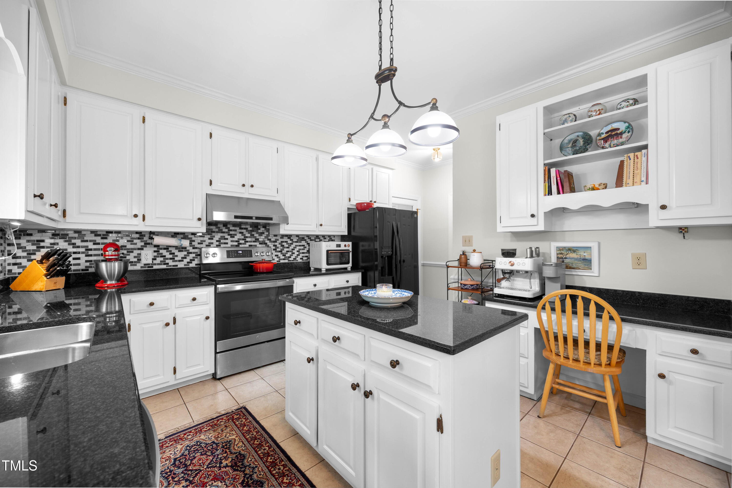 207 Wintermist Drive Cary, NC 27513 - Photo 5 of 43 a kitchen with stainless steel appliances kitchen island granite countertop a sink a stove a dining table and chairs with white cabinets