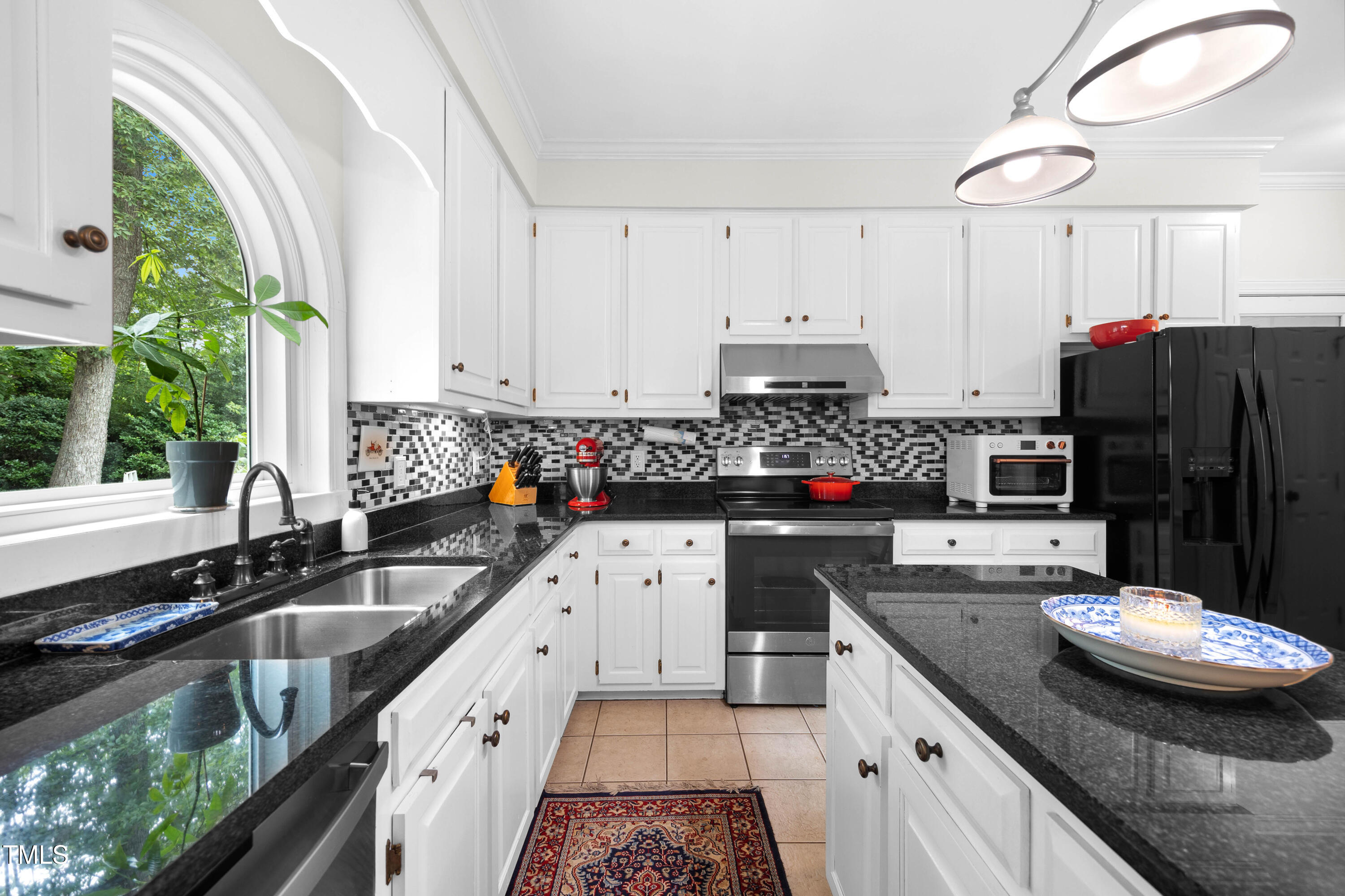 207 Wintermist Drive Cary, NC 27513 - Photo 8 of 43 a kitchen with stainless steel appliances a sink a stove a refrigerator cabinets and a window