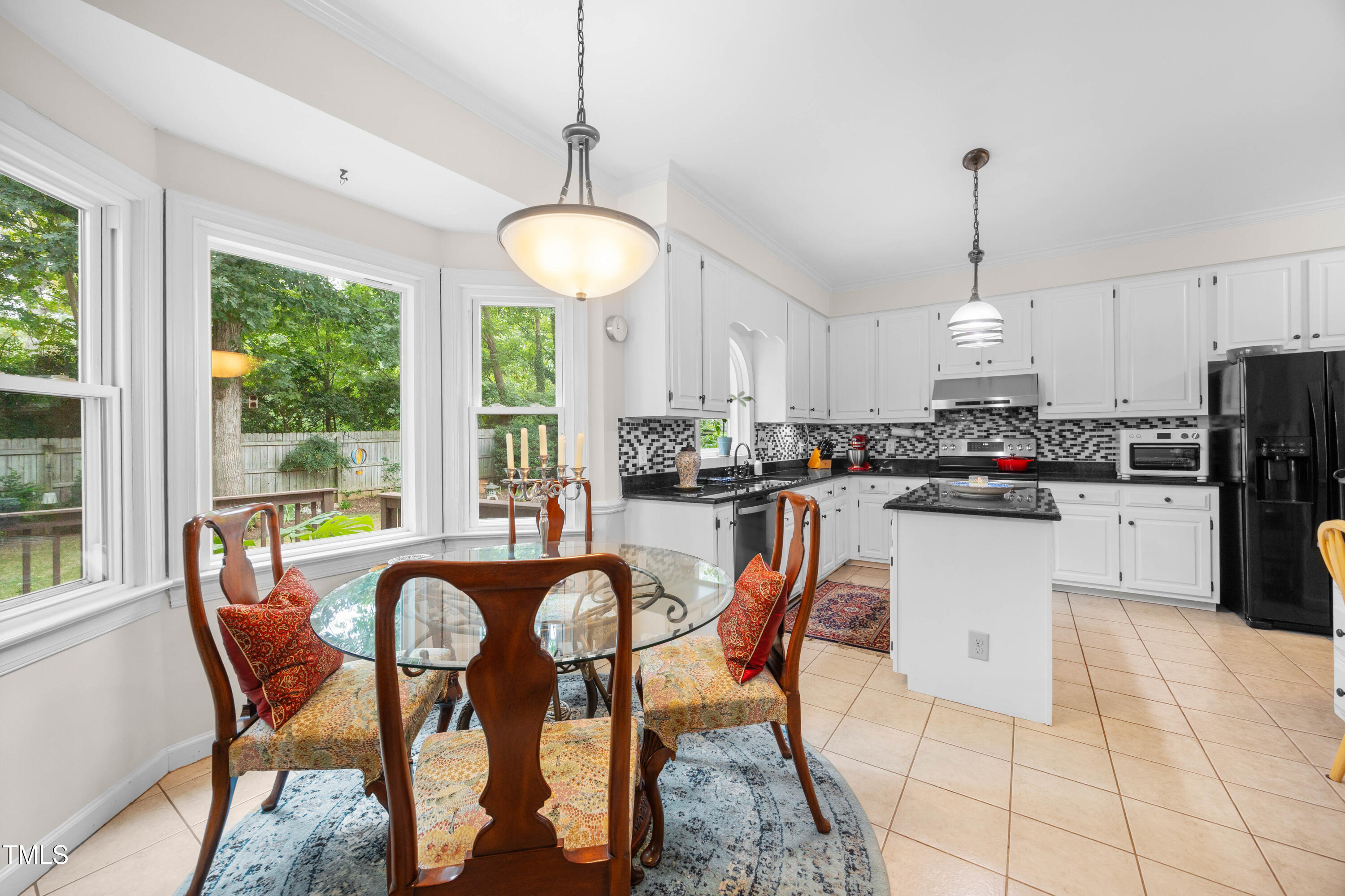 207 Wintermist Drive Cary, NC 27513 - Photo 9 of 43 a kitchen with stainless steel appliances granite countertop a stove a refrigerator a kitchen island a table and chairs with wooden floor
