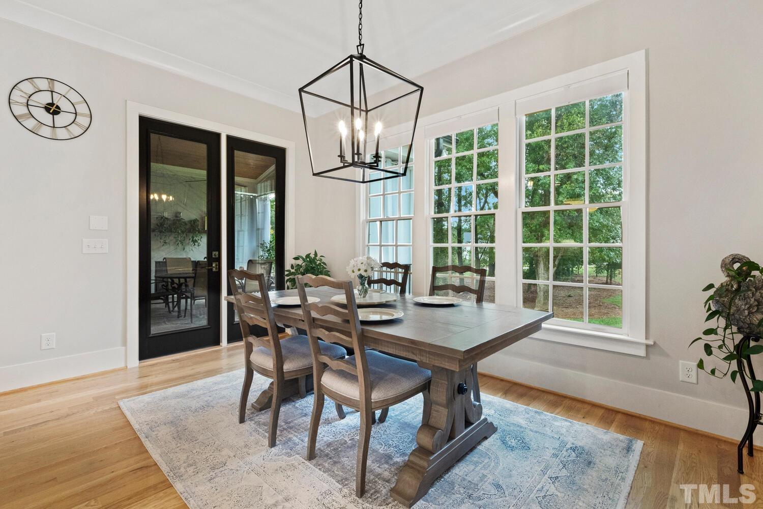 5105 Bella Ridge Drive Raleigh, NC 27615 - Photo 20 of 60 a dining room with wooden floor a chandelier a wooden table and chairs