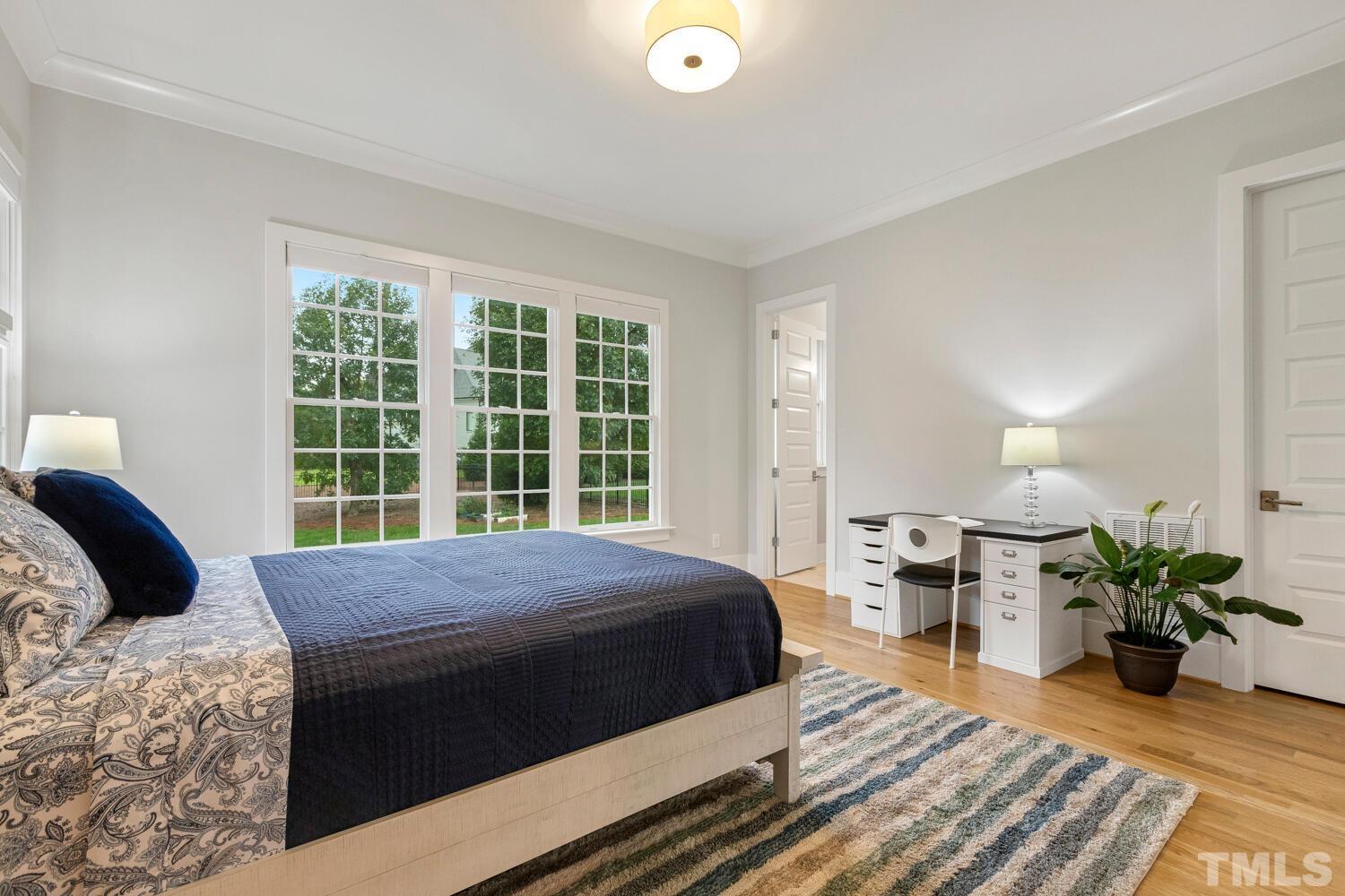 5105 Bella Ridge Drive Raleigh, NC 27615 - Photo 36 of 60 a bedroom with a bed potted plant on dresser and a large window