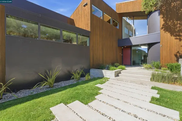a front view of a house with a garden and plants