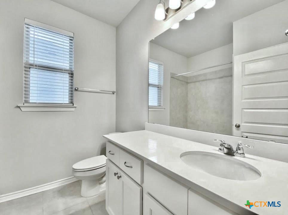 816 Alta Way Leander, TX 78641 - Photo 13 of 37 a bathroom with a granite countertop sink toilet and mirror