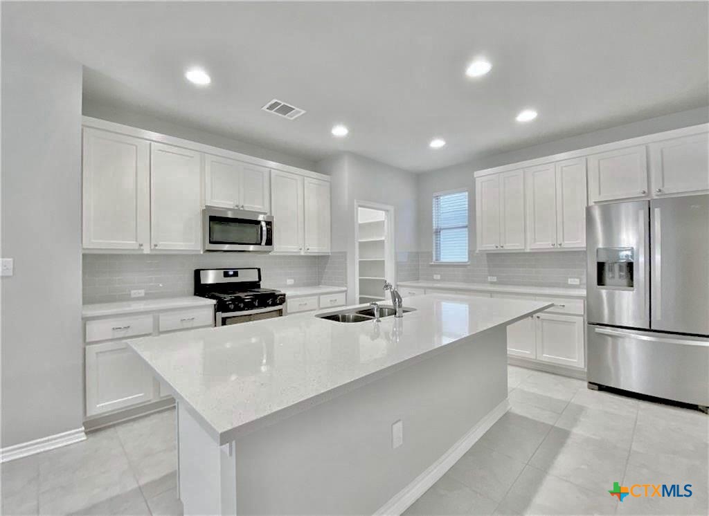 816 Alta Way Leander, TX 78641 - Photo 2 of 37 a kitchen with a sink stainless steel appliances and white cabinets