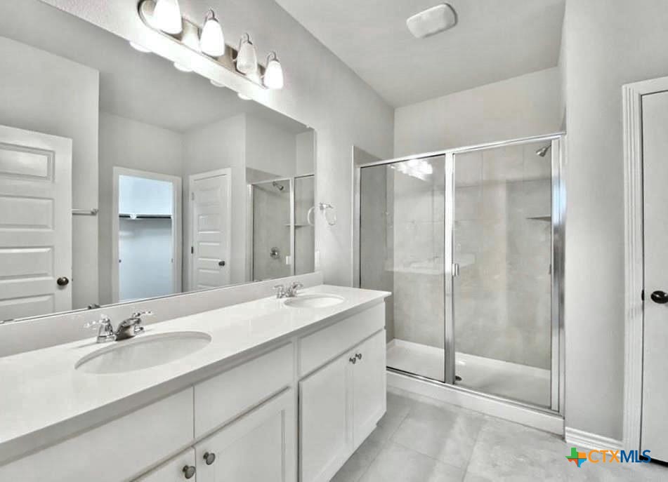 816 Alta Way Leander, TX 78641 - Photo 27 of 37 a bathroom with a double vanity sink mirror and shower