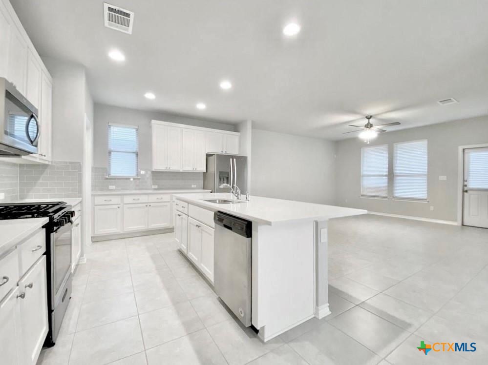 816 Alta Way Leander, TX 78641 - Photo 5 of 37 a kitchen with granite countertop a sink stove and cabinets