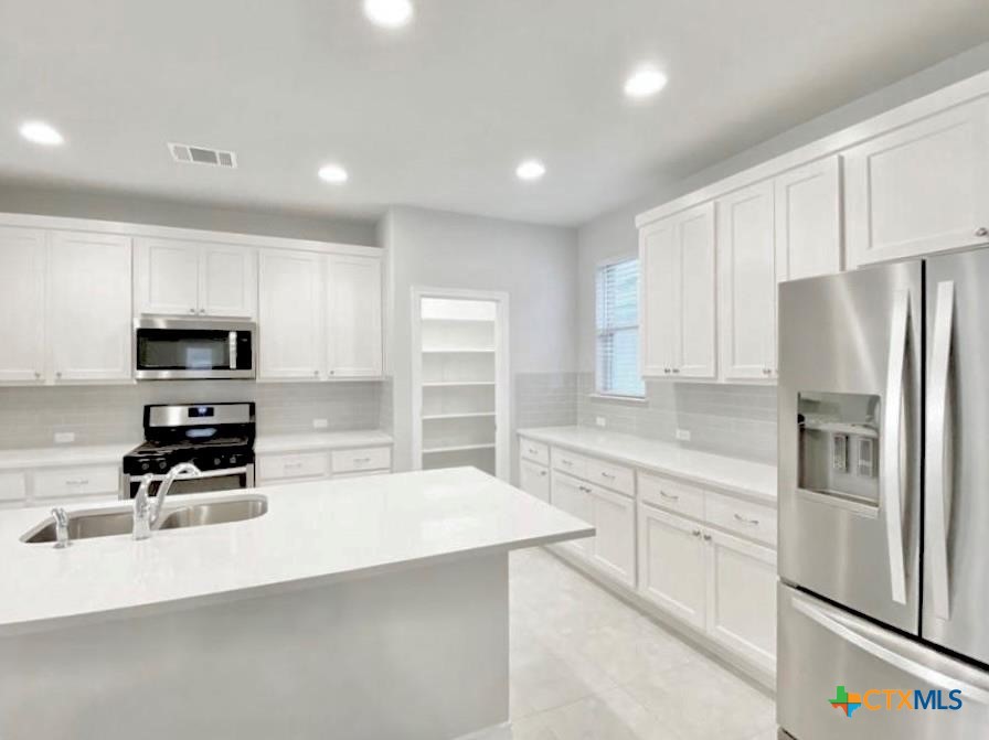 816 Alta Way Leander, TX 78641 - Photo 7 of 37 a kitchen with stainless steel appliances a refrigerator sink and microwave