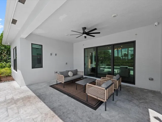 a living room with furniture a table and a large window