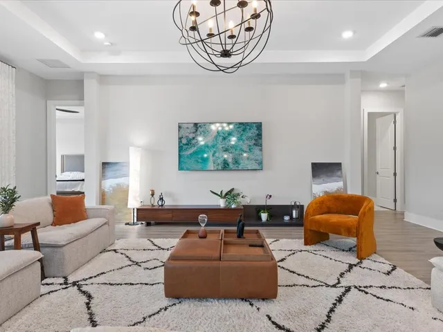 a kitchen with stainless steel appliances granite countertop a stove a sink a dining table and chairs with wooden floor