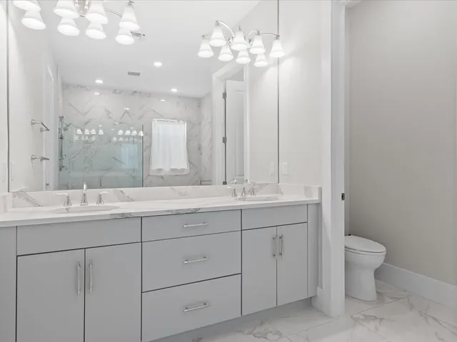 a bathroom with a granite countertop sink a toilet and bathtub