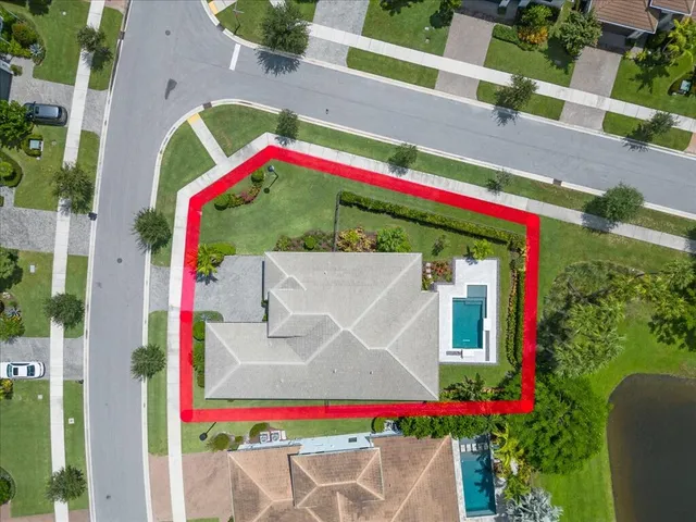 an aerial view of a house with outdoor space and a lake view in back