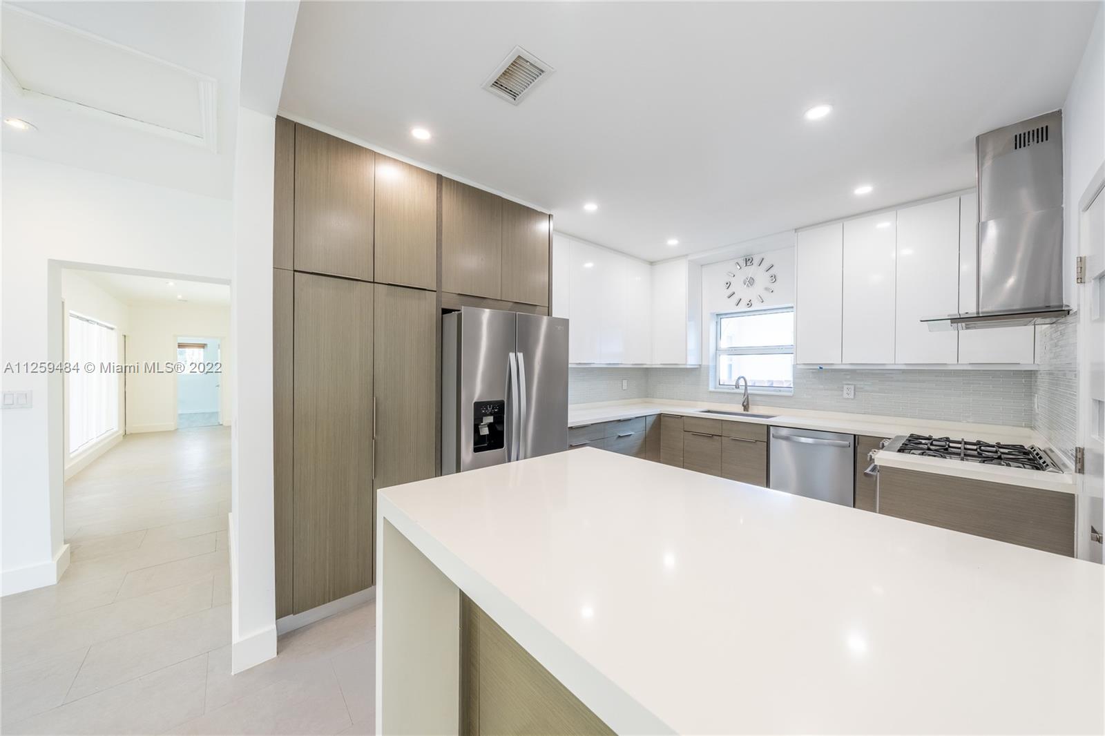 8810 Dickens Avenue Surfside, FL 33154 - Photo 5 of 15 a kitchen with stainless steel appliances a refrigerator sink and stove