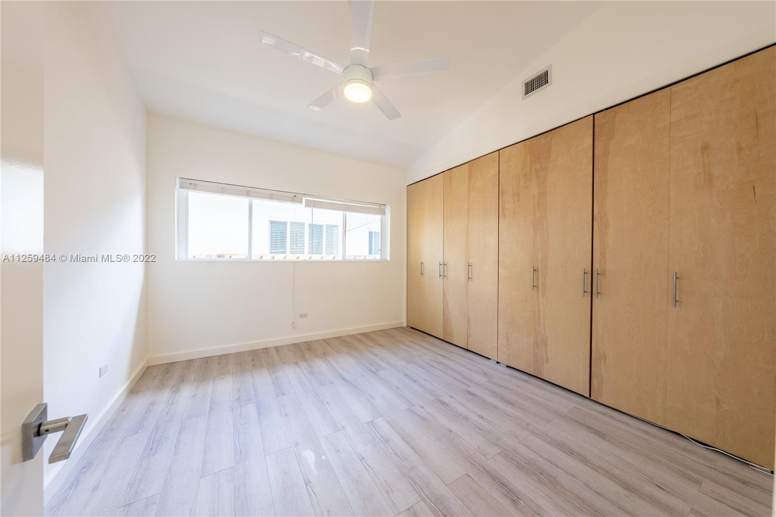 8810 Dickens Avenue Surfside, FL 33154 - Photo 7 of 15 an empty room with wooden floor and windows