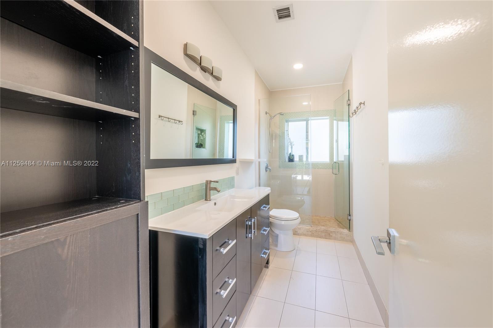 8810 Dickens Avenue Surfside, FL 33154 - Photo 8 of 15 a bathroom with a sink a toilet and mirror