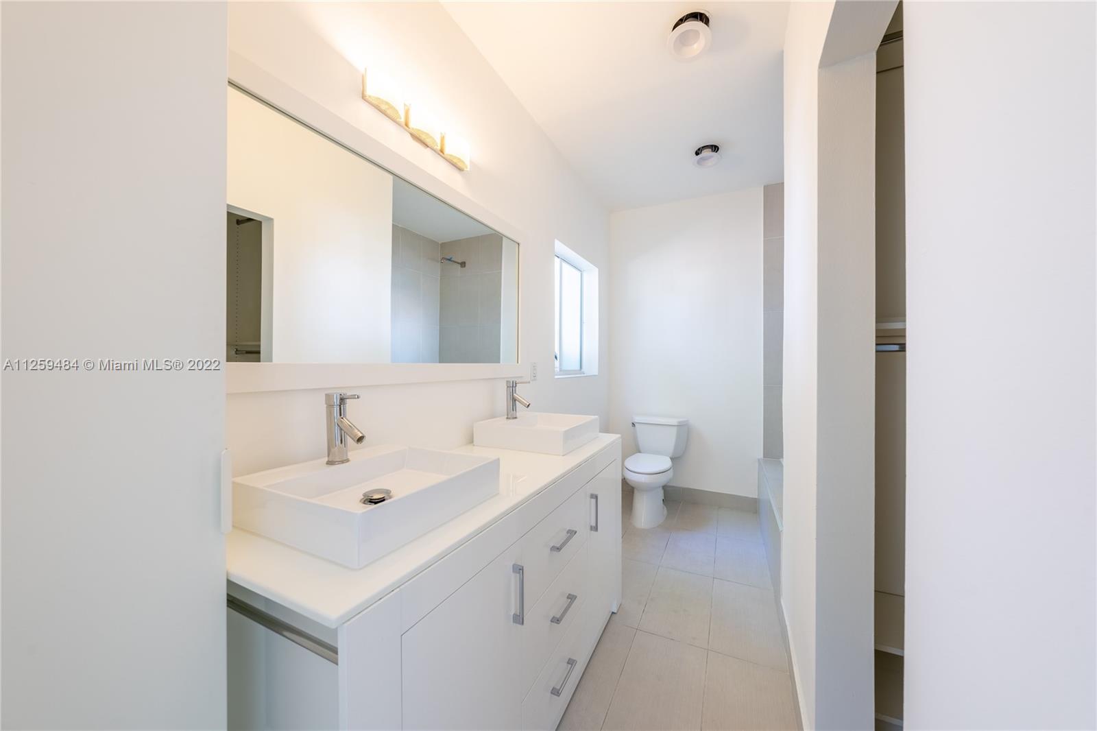 8810 Dickens Avenue Surfside, FL 33154 - Photo 10 of 15 a spacious bathroom with a double vanity sink and a mirror