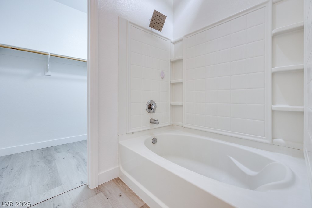 4915 East Russell Road, Unit 127 Las Vegas, NV 89120 - Photo 16 of 19 The sparkling white tub and shower enclosure with built-in shelving complement the light-toned flooring.