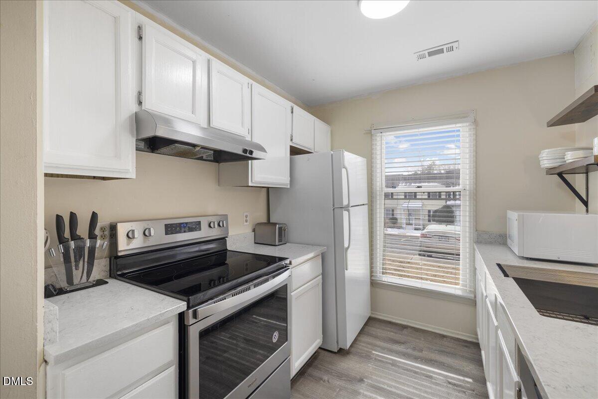 4 Astor Court Durham, NC 27705 - Photo 13 of 29 a kitchen with a stove and a refrigerator