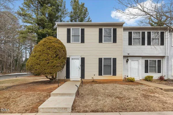 a view of a house with a yard and large tree