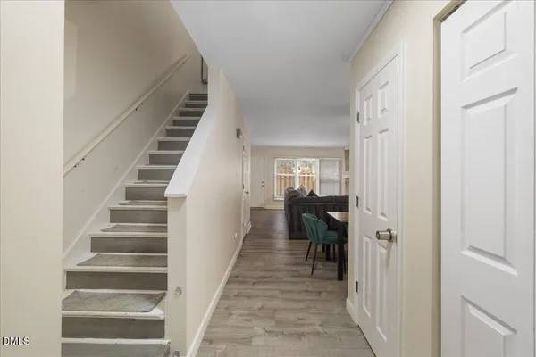 a view of a hallway with wooden floor and entryway