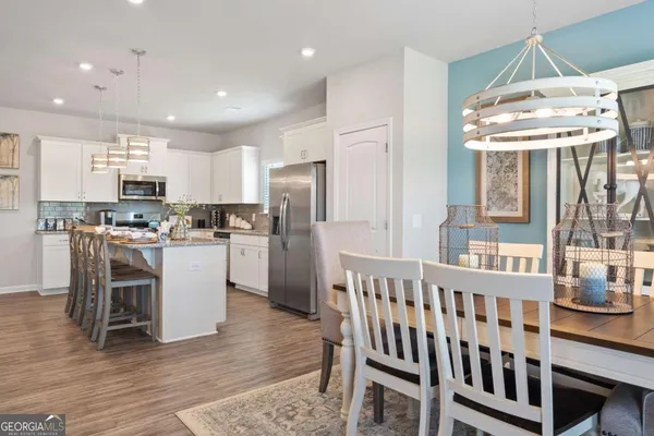 a kitchen with a table chairs refrigerator and microwave