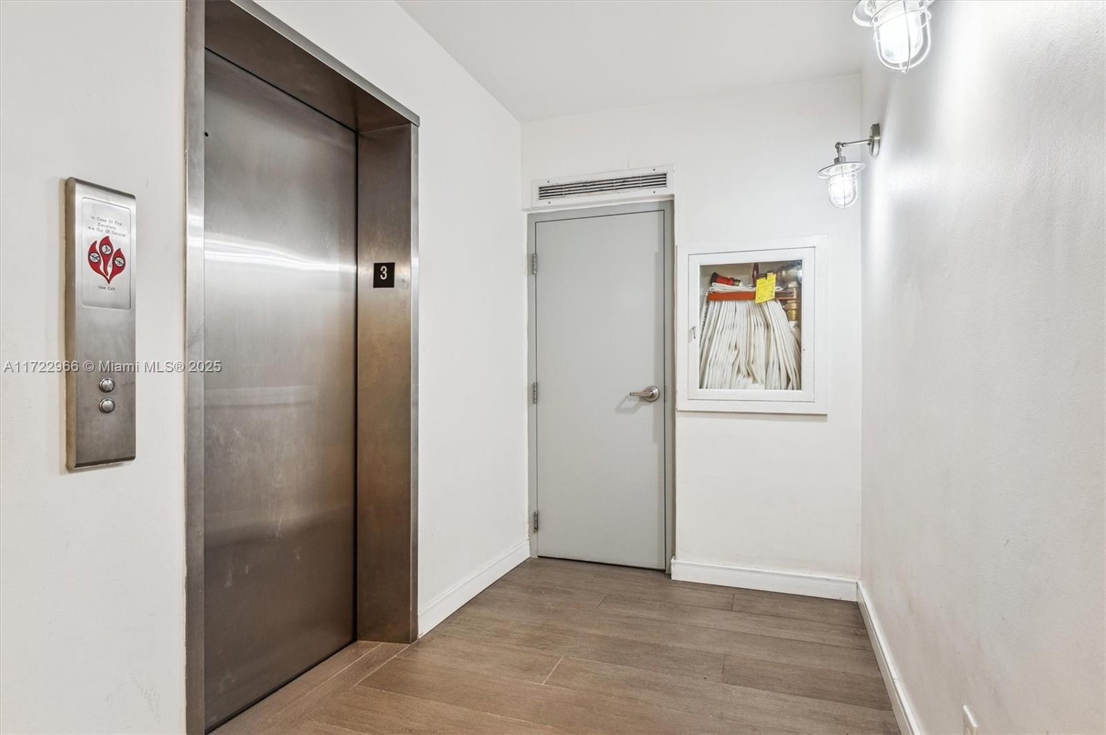 301 Sunrise Drive, Unit 3AW Key Biscayne, FL 33149 - Photo 13 of 23 a view of a hallway with wooden floor and a bathroom