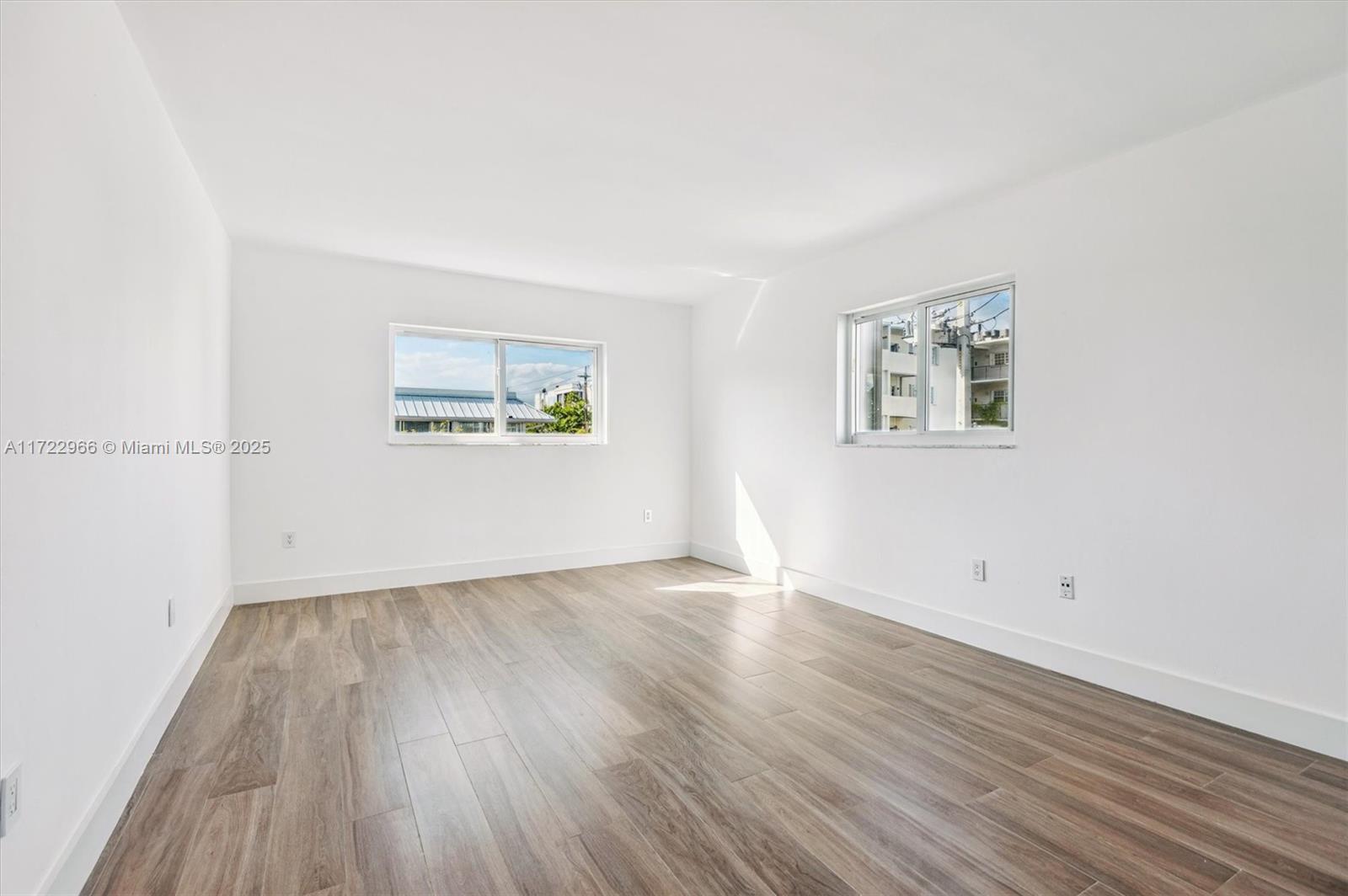 301 Sunrise Drive, Unit 3AW Key Biscayne, FL 33149 - Photo 15 of 23 an empty room with wooden floor and windows