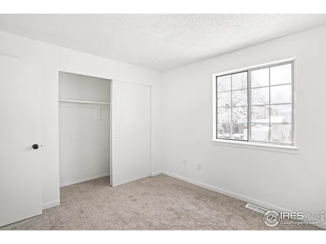 an empty room with windows and closet