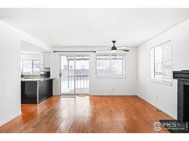 a view of an empty room with window and wooden floor