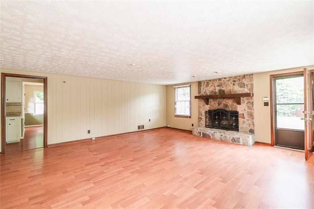 1291 Stephens Street Southwest Lilburn, GA 30047 - Photo 20 of 22 an empty room with fireplace and windows