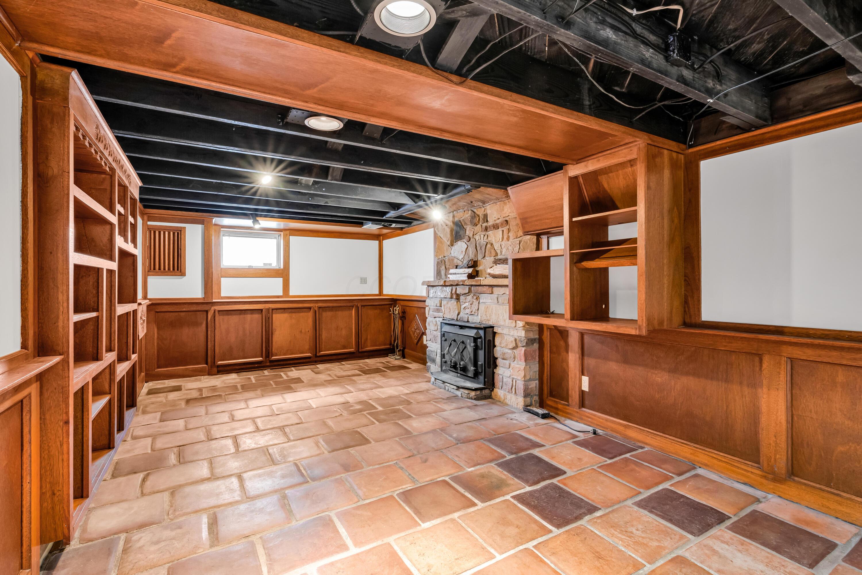 2033 Zollinger Road Columbus, OH 43221 - Photo 26 of 44 • Ceramic tile flooring
• Ivory painted & wainscoted
walls
• Built-in seating & storage
• Can lighting
• Lighted cedar closet
• Stone fireplace with
woodburning insert
• Built-in bookcases
• Water meter access