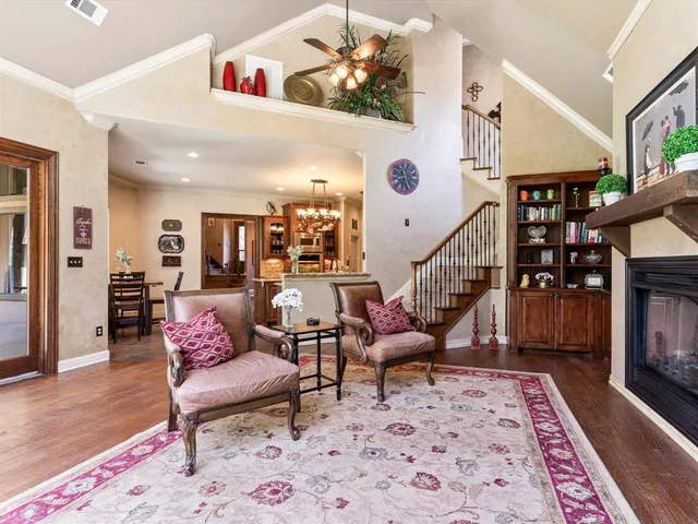 a living room with furniture a fireplace and a chandelier