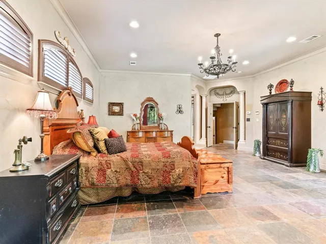 a bedroom with a bed and dresser with mirror