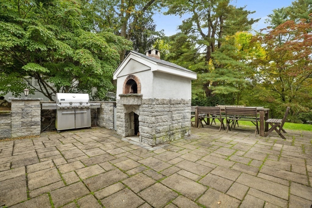 63 Brook Street Wellesley, MA 02482 - Photo 38 of 41 a view of a chairs and table in the back yard of the house