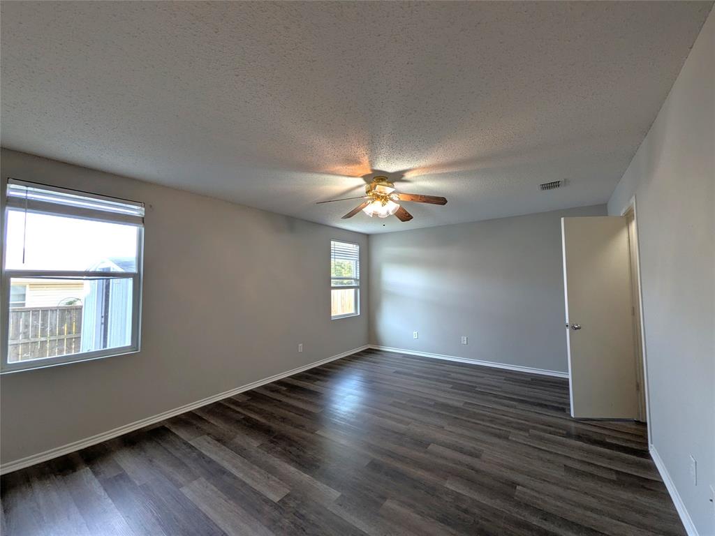 1736 Carolina Ridge Way Fort Worth, TX 76247 - Photo 16 of 33 Wood-finish flooring, neutral wall tones, two windows with blinds, a ceiling fan with integrated lighting, and a white interior door