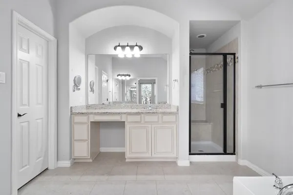 a spacious bathroom with a granite countertop sink a toilet and a mirror