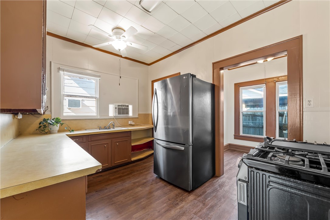 2721 Morrow Avenue Waco, TX 76707 - Photo 17 of 44 a kitchen with stainless steel appliances granite countertop a refrigerator a sink dishwasher a stove and white countertops with wooden floor