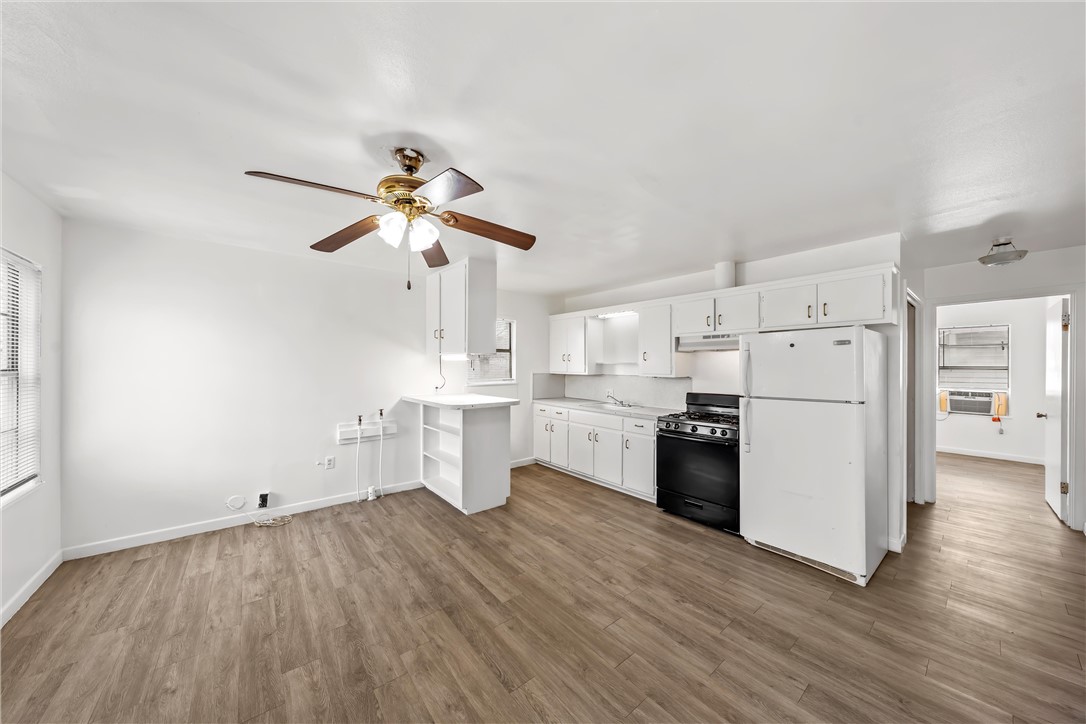 2721 Morrow Avenue Waco, TX 76707 - Photo 35 of 44 a kitchen with kitchen island a sink a stove and white cabinets