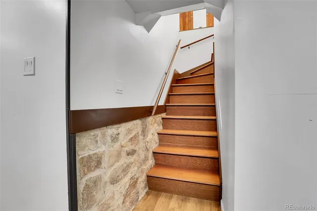 a kitchen with stainless steel appliances granite countertop a sink dishwasher a stove a refrigerator and a dining table with wooden floor