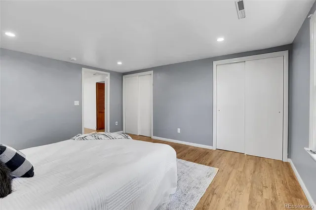 a spacious bedroom with a bed and a lamp