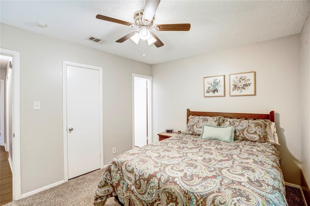 6028 Ridgecrest Drive Watauga, TX 76148 - Photo 18 of 40 a bedroom with a large bed and a chandelier