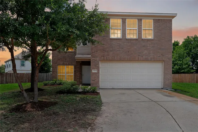 a front view of a house with yard and trees