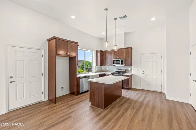 a view of a garden with plants and wooden fence