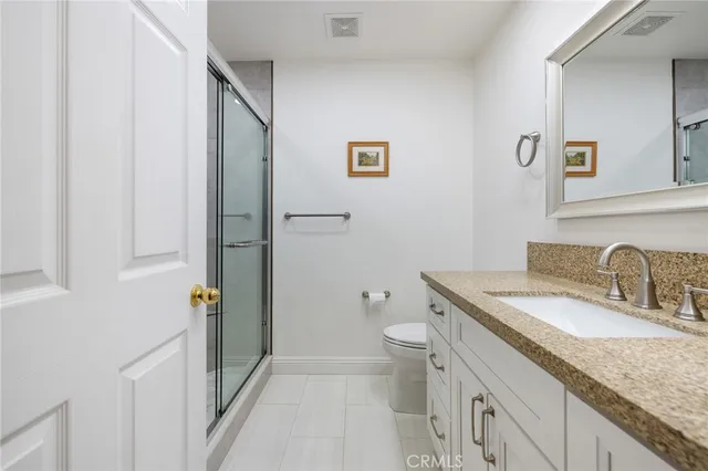 a bathroom with a granite countertop sink toilet and shower