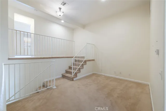 an empty room with windows & fan