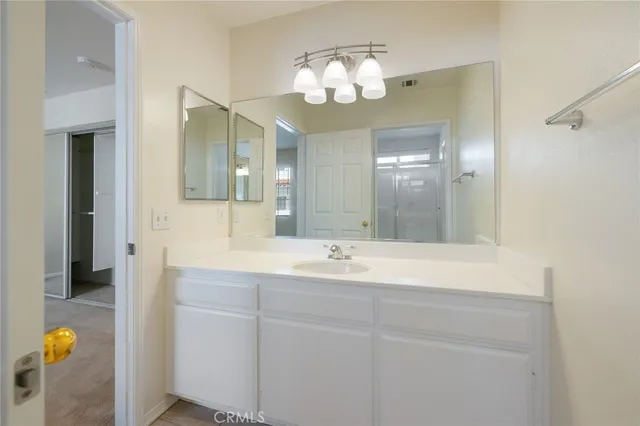 a bathroom with a sink a mirror a vanity and a shower