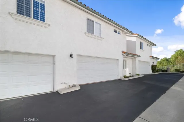 a front view of a house with a yard and potted plants