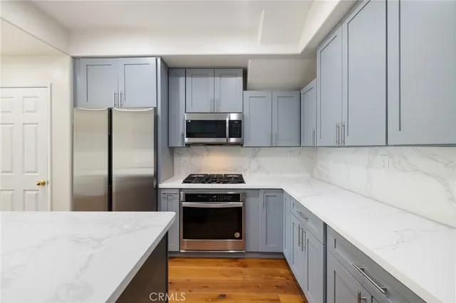 a kitchen with a stove top oven and refrigerator