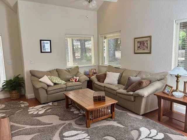 a living room with furniture a flat screen tv and a window