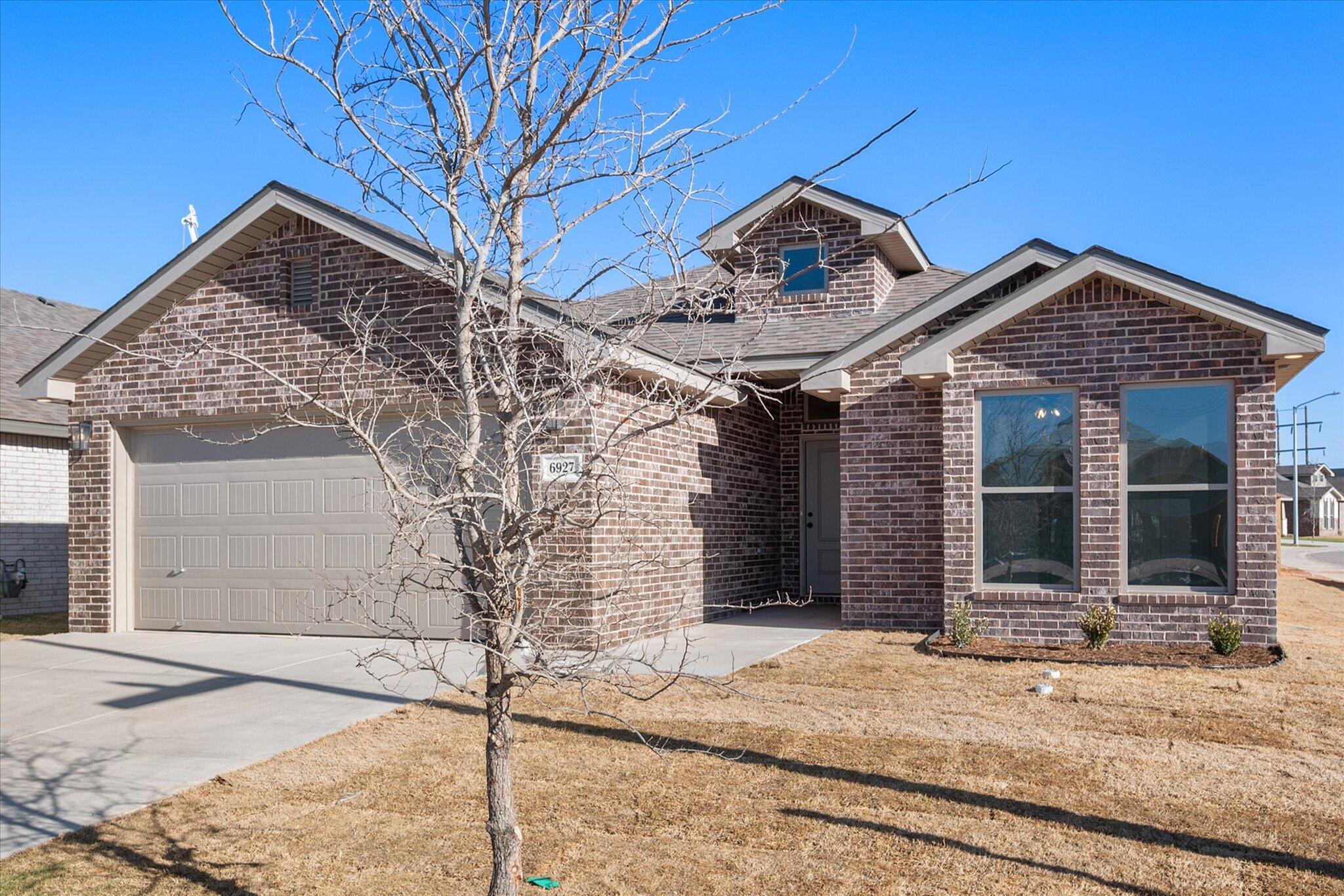 6927 53rd Street Lubbock, TX 79407 - Photo 1 of 21 a front view of a house with garden