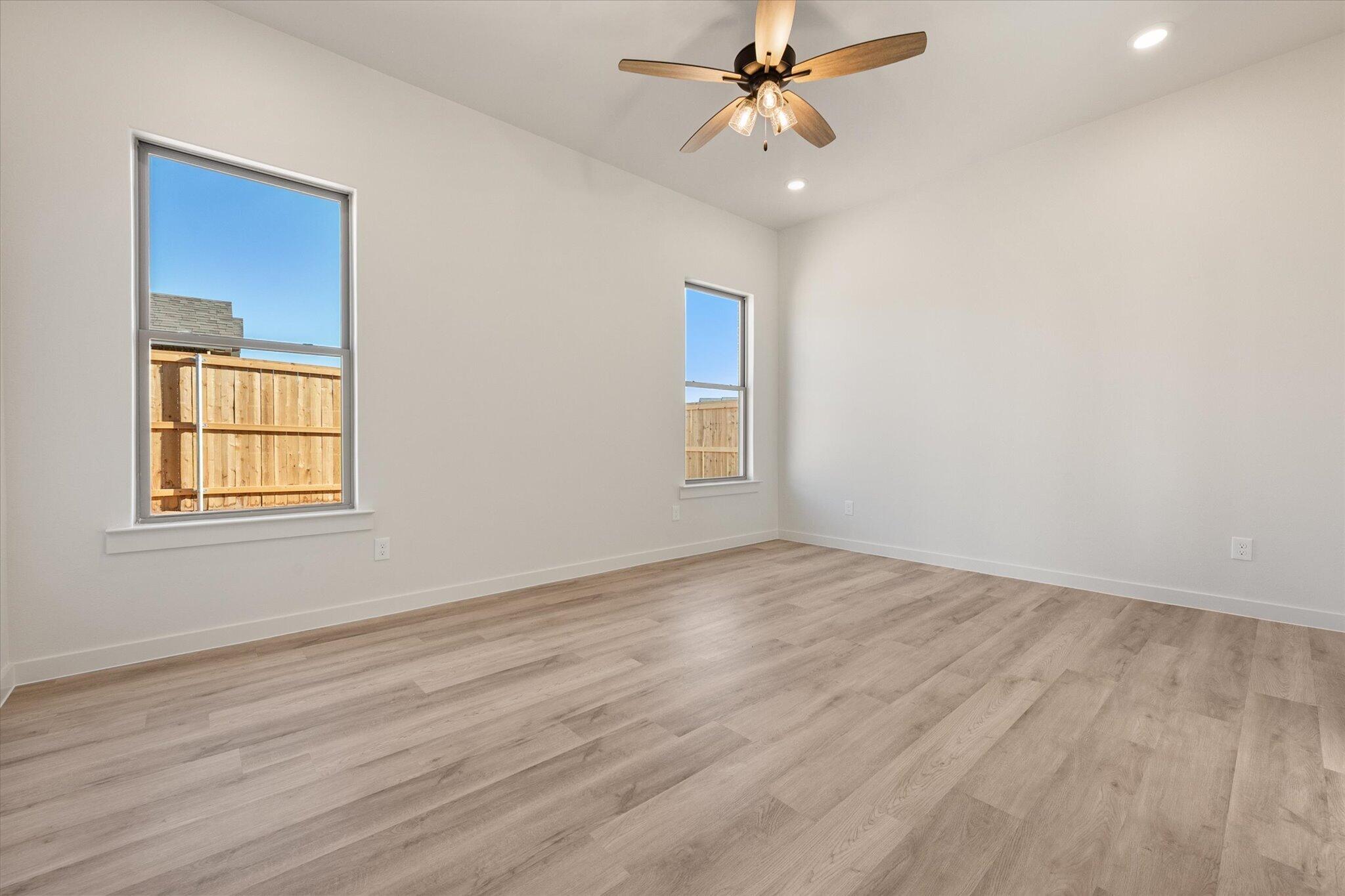 6927 53rd Street Lubbock, TX 79407 - Photo 19 of 21 an empty room with wooden floor fan and windows